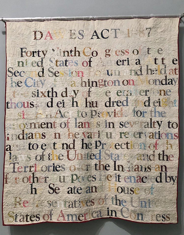 Gina Adams. Dawes Act 1887, Broken Treaty Quilt, 2019. Hand-cut cotton cloth, antique quilt. Vancouver, British Columbia, Canada. Photo: Antonio Rivera.