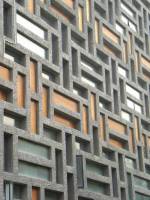 The interplay of glass, timber and openings among the textured concrete &lsquo;Mondrianese&rsquo; grid at the rear elevation of the building.