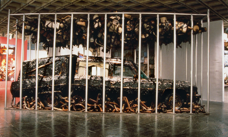 Nari Ward, Peace Keeper, 1995. Hearse, grease, mufflers, and feathers, 144 x 116 x 264 in (365.8 x 294.6 x 670.6 cm). Installation views: Whitney Museum of American Art, New York, 1995. Courtesy the artist, Lehmann Maupin, New York, Hong Kong, and Seoul, and Galleria Continua, San Gimignano, Beijing, Les Moulins, and Havana (page 234).