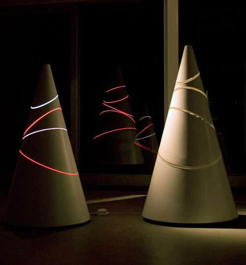 Liliane Lijn. Clear Light Koan respectively, 2008. Glass fibre, Polyester resin, 20mm thick Clear Perspex sections, motorised turntable, 170 x 96 cm diameter; Clear Red Koan, 2008. Glass fibre, Polyester resin, Fluorescent Red, Orange and Green Perspex,
motorised turntable, fluorescent light, 153 x 80 cm base diameter. Government Art Collection. Photograph: Liliane Lijn
.
