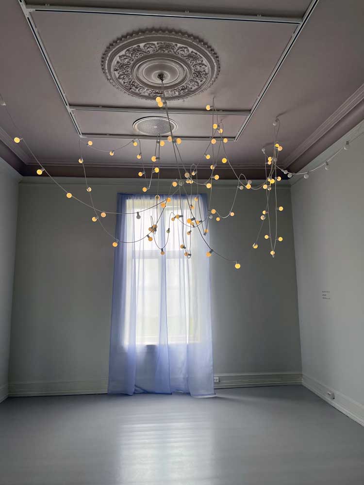 Katie Paterson. Festoon lights as Ara constellation, with silk curtains beyond, dyed the colour of the first stars. Installation view, Galleri F15, Moss, Norway. Photo: Veronica Simpson.